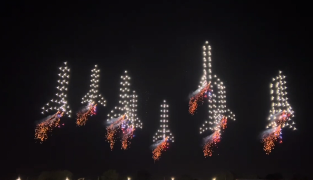 Drone light show displaying arrow formations at night